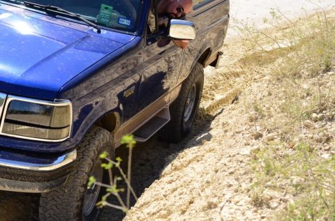 1996 Ford Bronco - This blue 1996 Ford Bronco navigates a sandy, off-road path, kicking up dust.