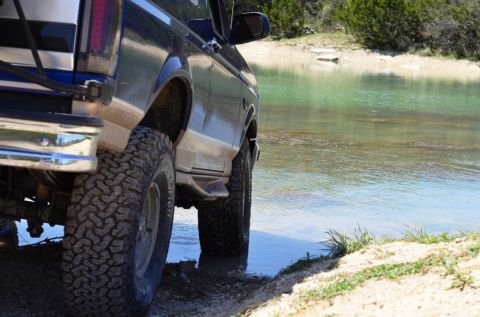 1996 Ford Bronco - A dark blue 1992 Ford Bronco drives into a body of water.