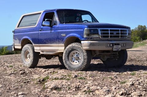 1996 Ford Bronco - This 1996 Ford Bronco is shown off-road on a rocky surface under a clear blue sky.