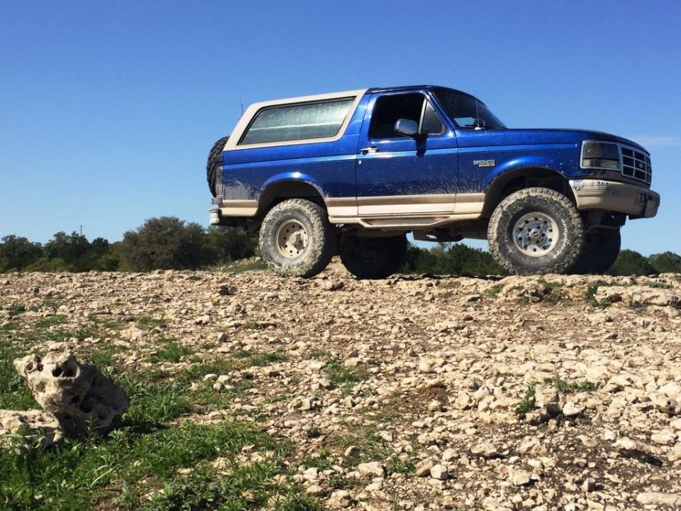 Blue 1996 Ford Bronco on rocky terrain