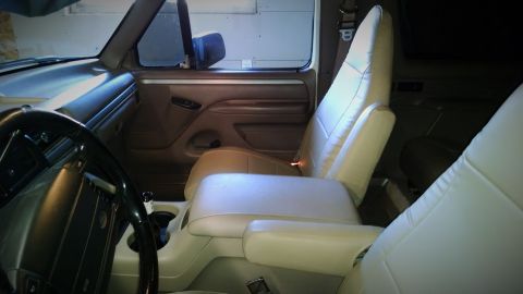 1994 Ford Bronco - Interior view of a car, showing tan seats and dashboard details, with a SuperMotors logo in the corner.