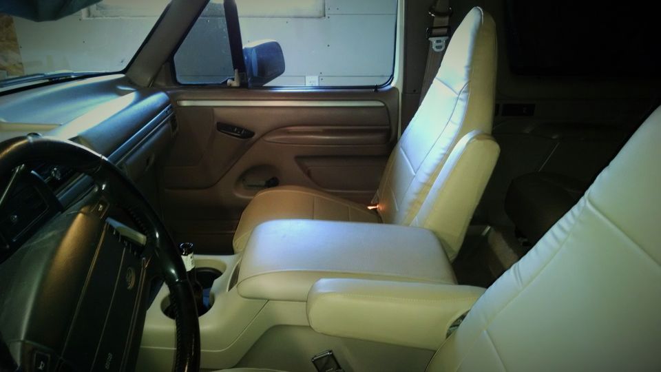 Interior view of a vehicle with tan seats and center console