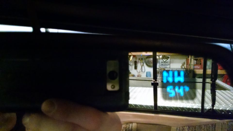 Interior rearview mirror showing a digital display with 'NW' and '54'