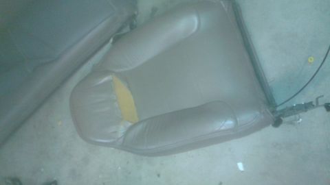 1996 Ford Bronco - A detached car seat shows wear with a tear revealing yellow material underneath.