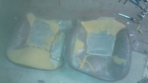 1996 Ford Bronco - Two car seats are visible, showing torn upholstery and protective plastic covering.