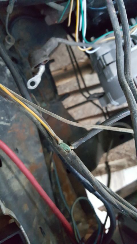 1978 Ford Bronco - Close-up of an engine wiring harness showing a frayed green wire and a metal lug connector.