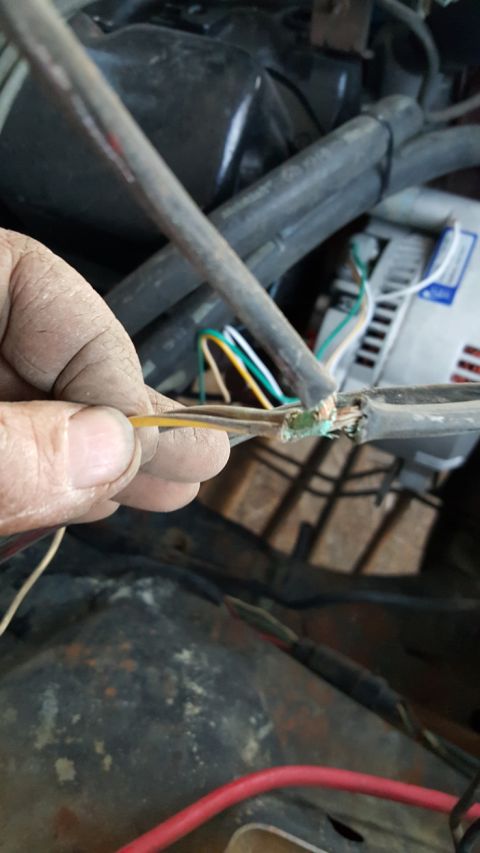 1978 Ford Bronco - Close-up of engine bay wiring being repaired, with frayed wires and connectors visible.