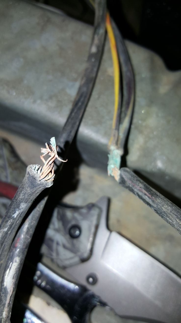 frayed electrical wires with exposed copper strands and green corrosion on one end