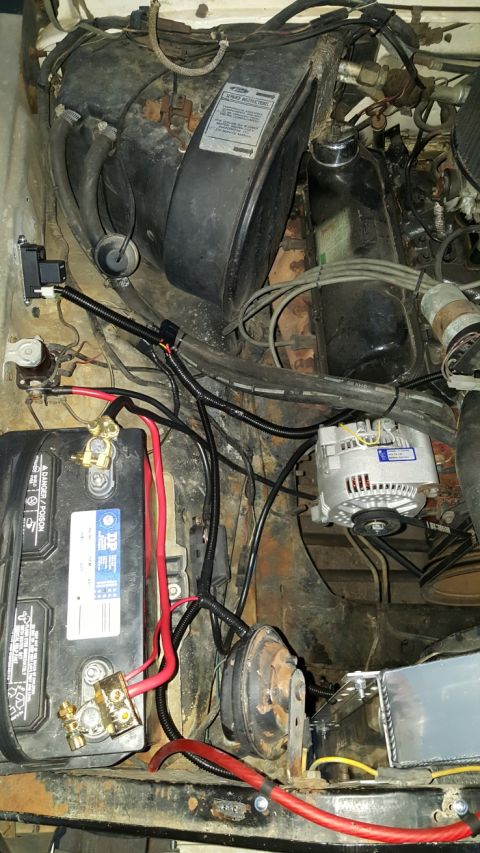 1978 Ford Bronco - Close-up view of a vehicle's engine bay, showing the battery, alternator, and various electrical components.