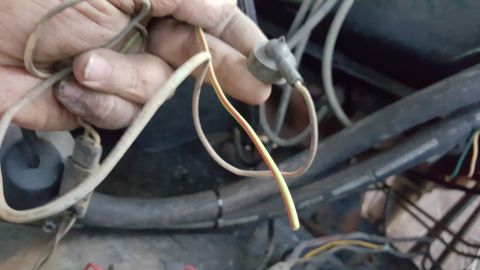 1978 Ford Bronco - Close-up of a hand holding electrical wires, likely in an engine bay.