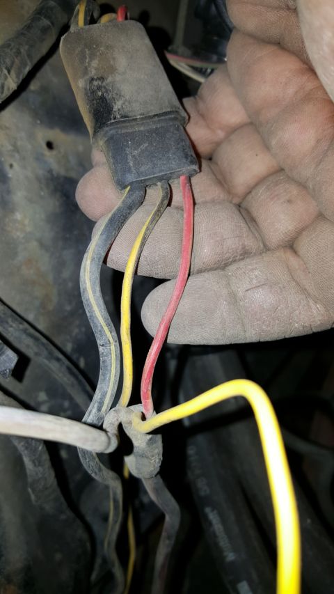 1978 Ford Bronco - A hand holds a dirty electrical connector with multiple wires attached, suggesting a repair or modification.
