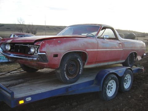 1971 Ford Ranchero - This 1971 Ford Ranchero is being transported on a trailer, showing its distinctive pickup truck bed and car front.