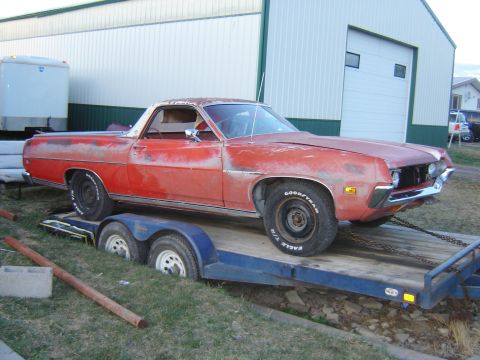 1971 Ford Ranchero - Red pickup truck on a trailer, showing its front and side profile. The vehicle appears to be a 1970s model.