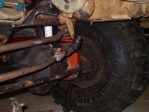 1996 Ford Bronco - The photo shows the steering and suspension system of a vehicle, focusing on the tie rods and ball joints near the wheel.