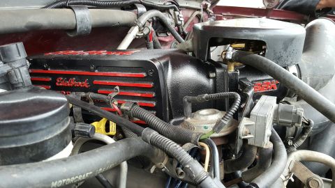 1996 Ford Bronco - Engine bay detail showing aftermarket Edelbrock valve covers on a vehicle's motor.