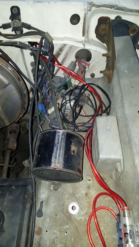 1978 Ford Bronco - Close-up of a vehicle's engine bay, showing a complex wiring harness and a black cylindrical component.