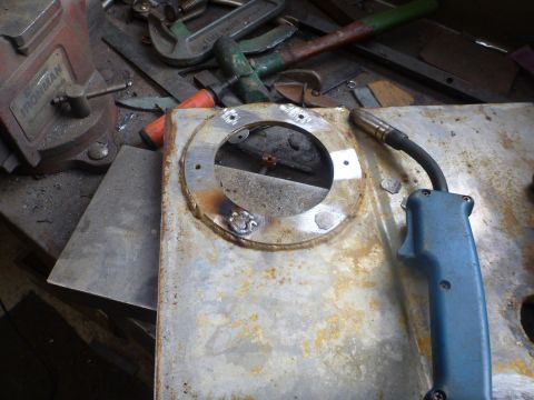 1969 MINI Cooper - Close-up of a rusty metal part, possibly a fuel tank, with a welding torch nearby.