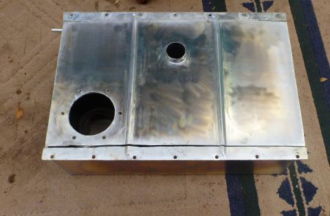 1969 MINI Cooper - A metal fuel tank with multiple rivets and two large circular openings is shown from above.