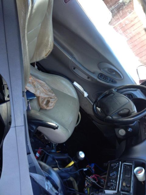 1995 Ford Probe - Interior view of a 1995 Ford Probe showing a deployed airbag and a damaged driver's seat.