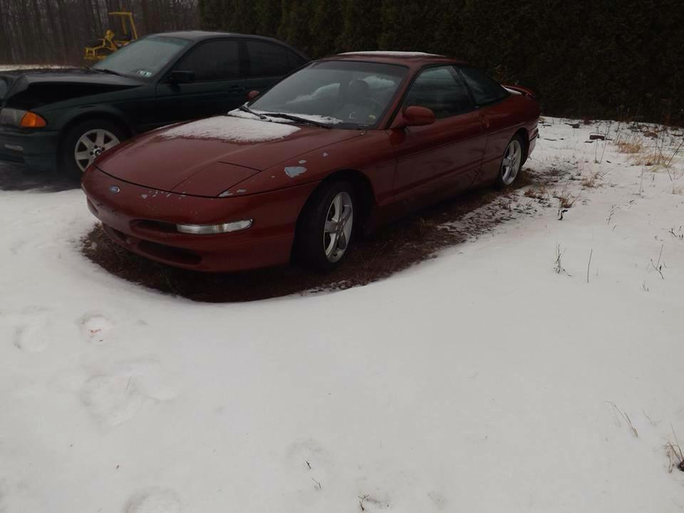 Red 1995 Ford Probe parked in the snow.