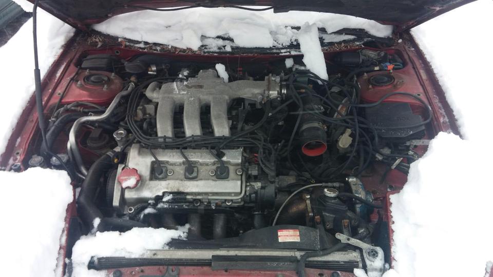 1995 Ford Probe engine bay covered in snow.