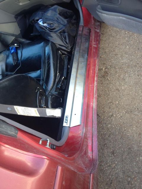 1995 Ford Probe - The interior of a red car's driver side door is shown, with black leather seats and a black duffel bag visible. A set of Allen wrenches is…