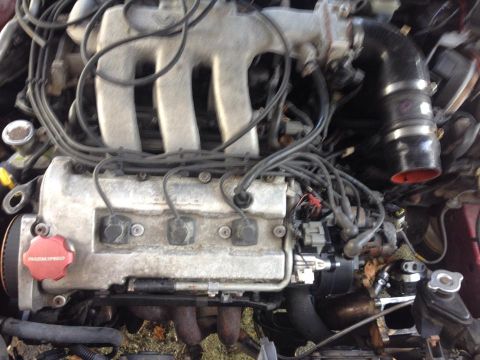 1995 Ford Probe - This is a close-up, overhead view of a Mazda engine, likely from a 1990s era vehicle. Visible components include the intake manifold, spark…