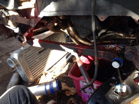1995 Ford Probe - A close-up view of a vehicle's engine bay with various parts, including an intercooler, exhaust manifold, and suspension components, laid o…