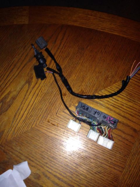 1995 Ford Probe - A collection of wiring harnesses and connectors, some with labels, are laid out on a wooden surface. One harness has a handwritten label th…