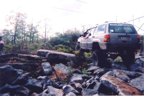 1978 Ford Bronco - This Jeep is navigating a difficult rocky terrain, with the driver actively engaged.