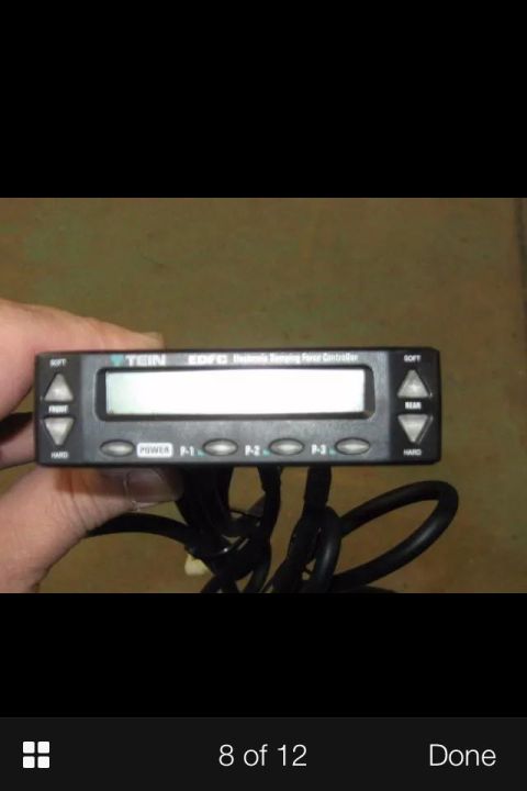 1995 Ford Probe - A hand holds a TEIN EDFC Electronic Damping Force Controller with a digital display and several buttons labeled POWER, P-1, P-2, and P-3. T…