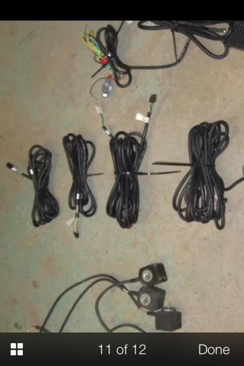 1995 Ford Probe - A collection of various automotive wiring harnesses and electrical components are laid out on a concrete floor.