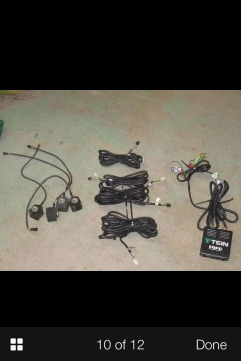 1995 Ford Probe - Several bundles of black wiring harnesses and what appear to be electronic control modules are laid out on a concrete surface. One black bo…