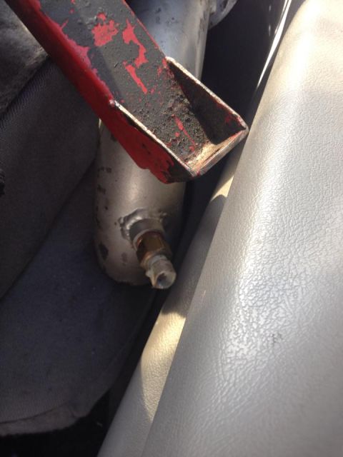 1995 Ford Probe - A close-up view shows a red and black metal bracket attached to a silver cylindrical part with a brass fitting. The bracket appears worn an…