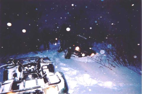 1978 Ford Bronco - Two off-road vehicles navigate a snowy terrain under a starry night sky.