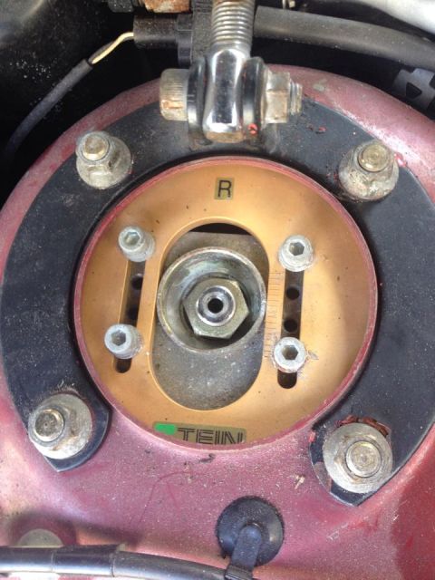 1995 Ford Probe - A close-up view of a gold-colored adjustable strut mount with the letter "R" indicating the right side. The mount is branded with "TEIN" an…