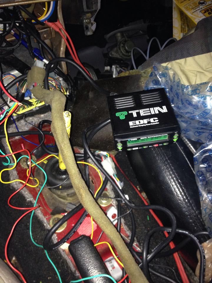 TEIN EDFC controller unit with green lettering among vehicle wiring.