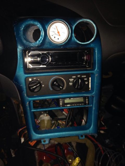 1995 Ford Probe - The image shows a close-up view of a car's dashboard with a blue painted trim around the center console. Visible components include a car s…