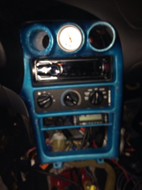 1995 Ford Probe - A close-up interior shot shows a modified dashboard with a blue painted bezel. Visible components include a car stereo, climate controls, a…
