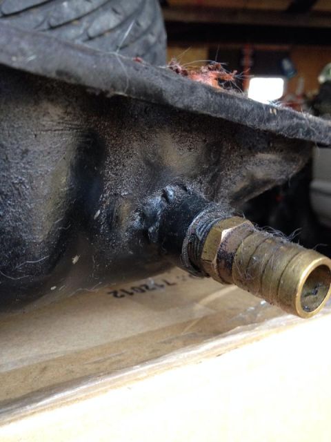1995 Ford Probe - A close-up view shows a black, textured part with a brass fitting and hose attached. Visible text on the surface reads "112012".