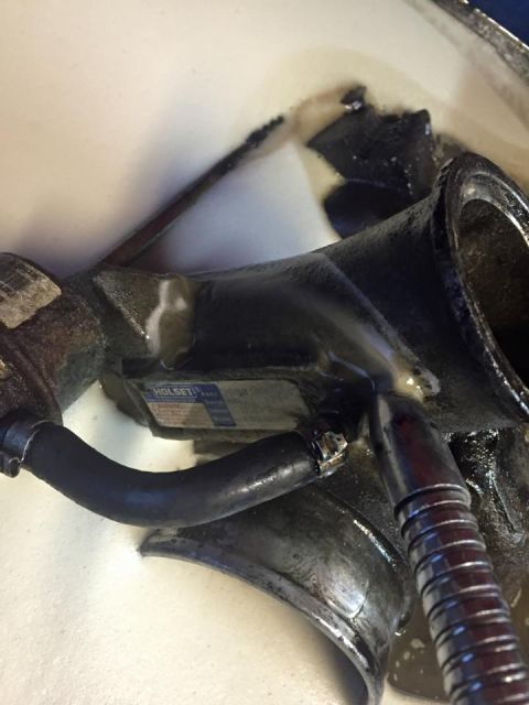 1995 Ford Probe - A close-up view of a turbocharger component, possibly from a 1995 Ford Probe, with a black rubber hose attached. A label with the text "HOL…