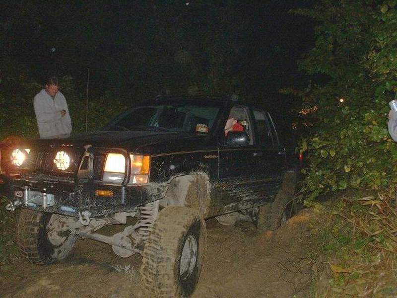 Black off-road SUV with aftermarket bumper and lights at night