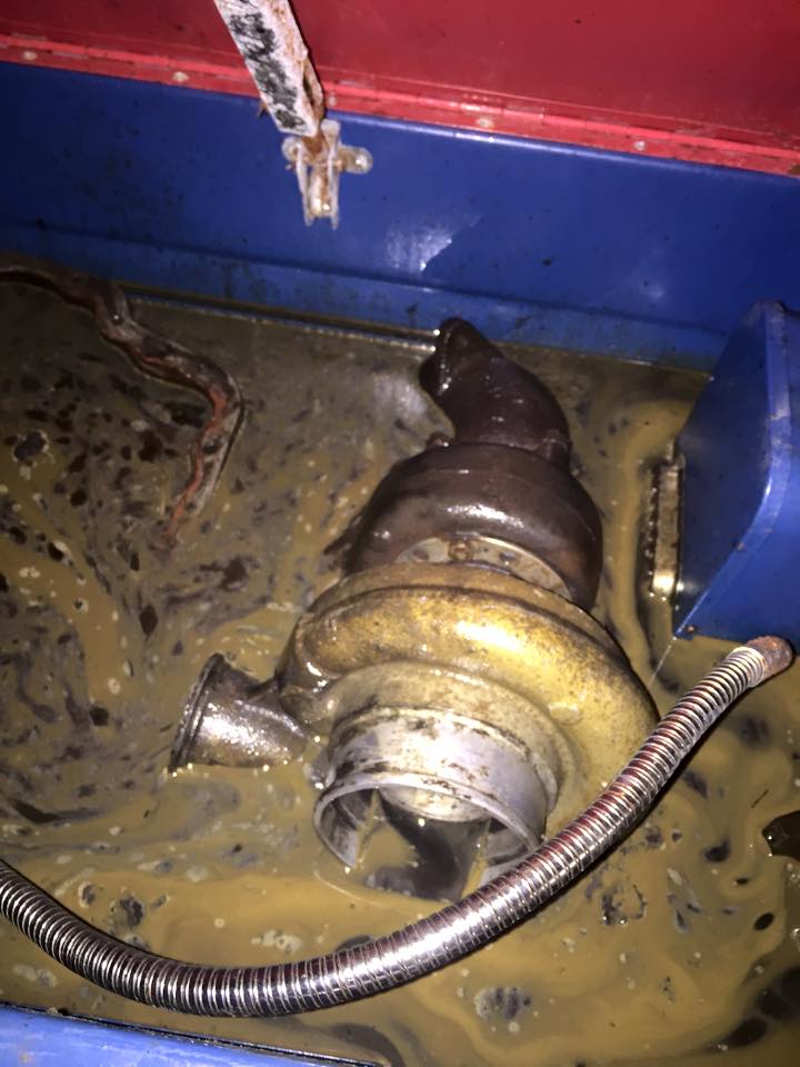 Turbocharger submerged in murky fluid