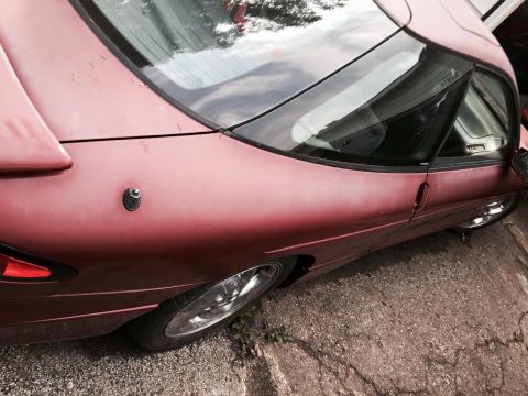 1995 Ford Probe - Close-up of a red car's rear quarter panel and taillight.