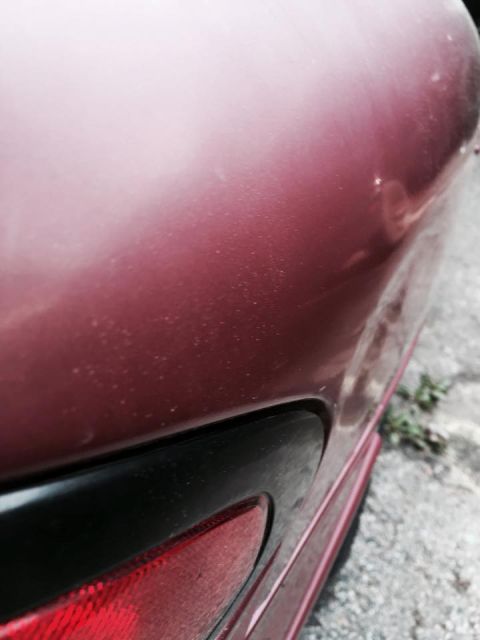 1995 Ford Probe - Close-up of the rear quarter panel of a 1995 Ford Probe, showing the car's red paint.