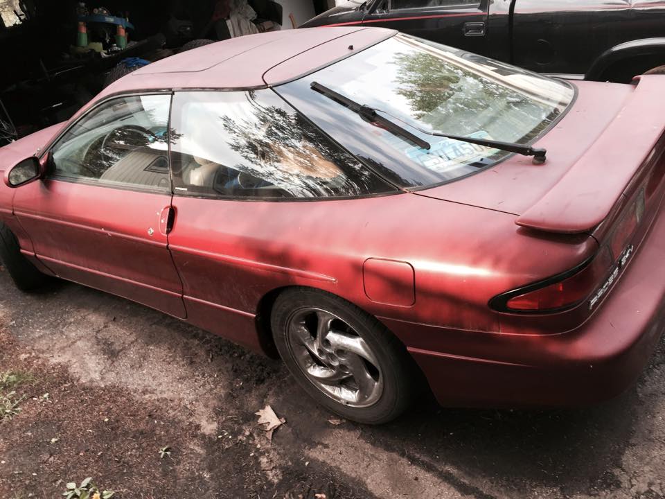 Red Ford Probe coupe with spoiler, rear wiper, and aftermarket wheels.