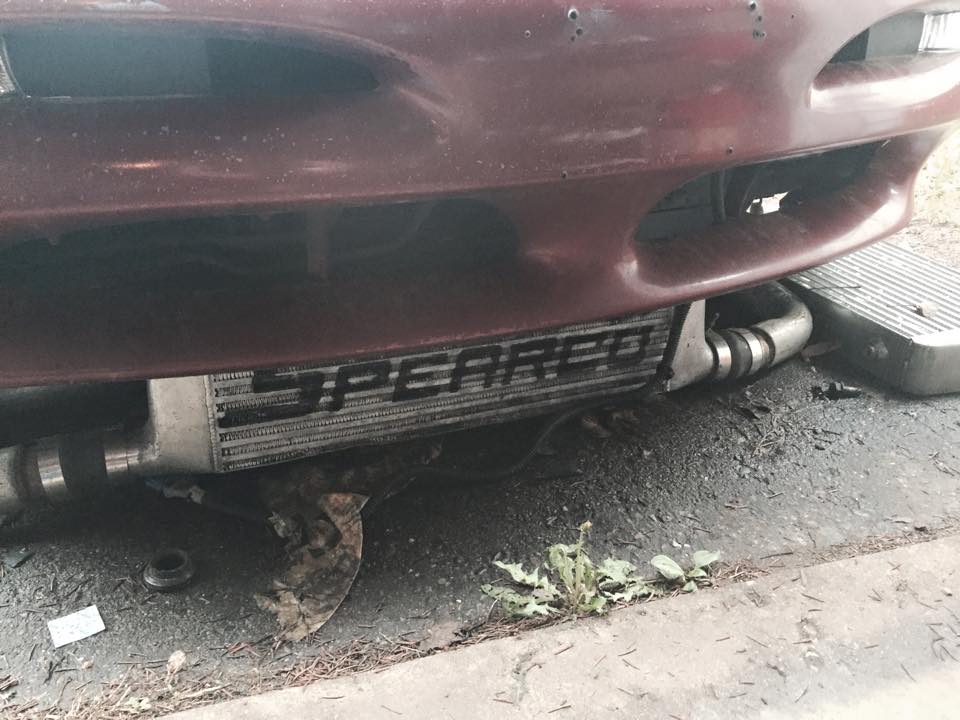 Custom SPEARCO intercooler installed on a dark red vehicle below the front bumper.