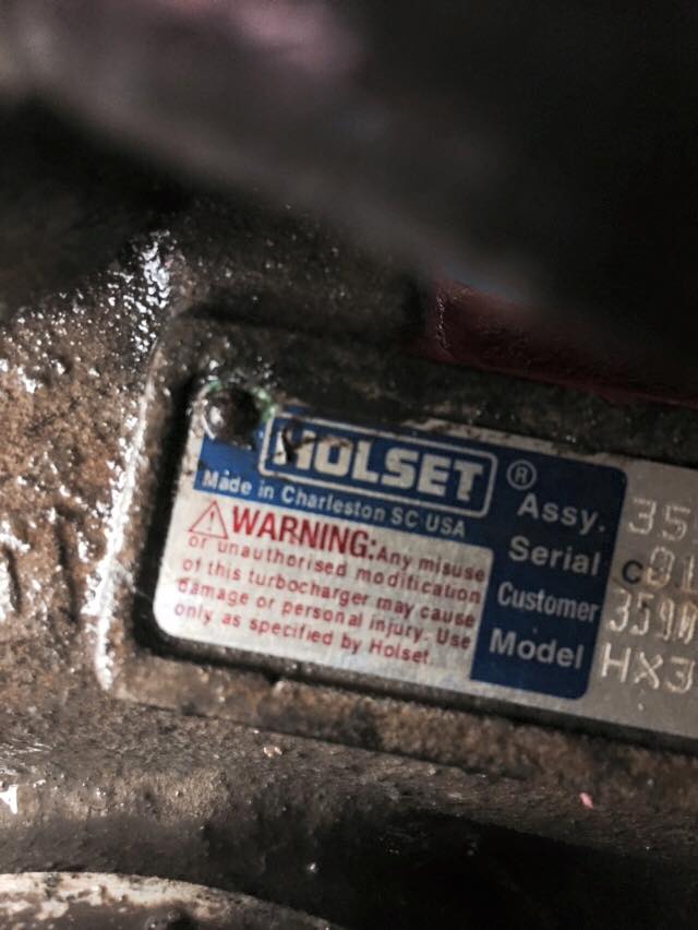 Close-up of a Holset turbocharger identification plate with warning text.