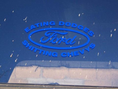 1978 Ford Bronco - A blue vehicle window displays a humorous Ford logo sticker with text about other car brands.