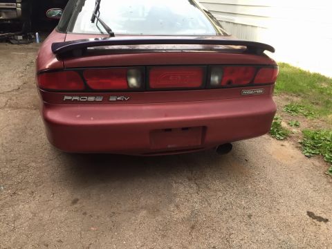 1995 Ford Probe - The rear view of a red 1995 Ford Probe GT with a spoiler and a "Mazdaspeed" badge. The car is parked on a concrete driveway next to grass.